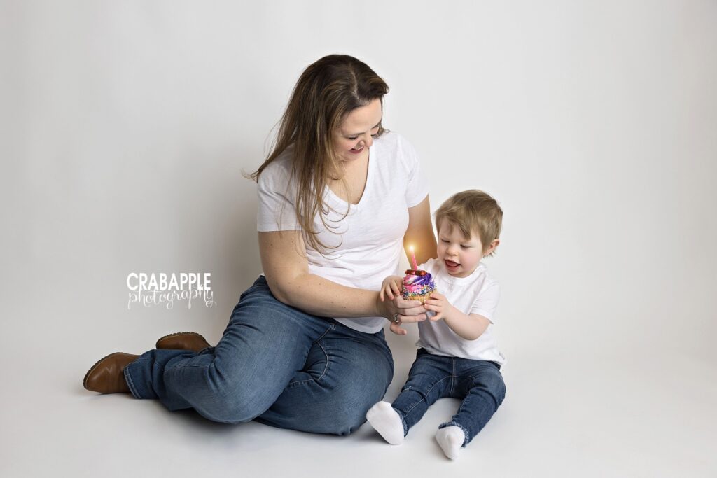 Toddler girl sharing cupcake with mom during studio portrait session in Andover MA

