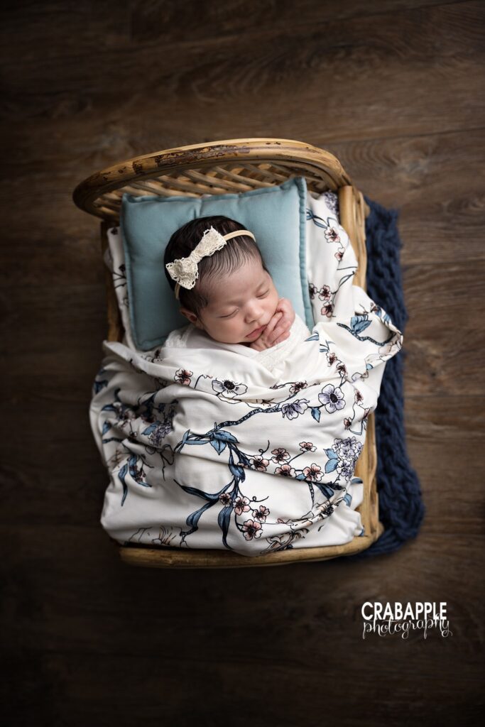 Wooden Bed Newborn Baby girl posed on wooden bed with blue floral newborn styling