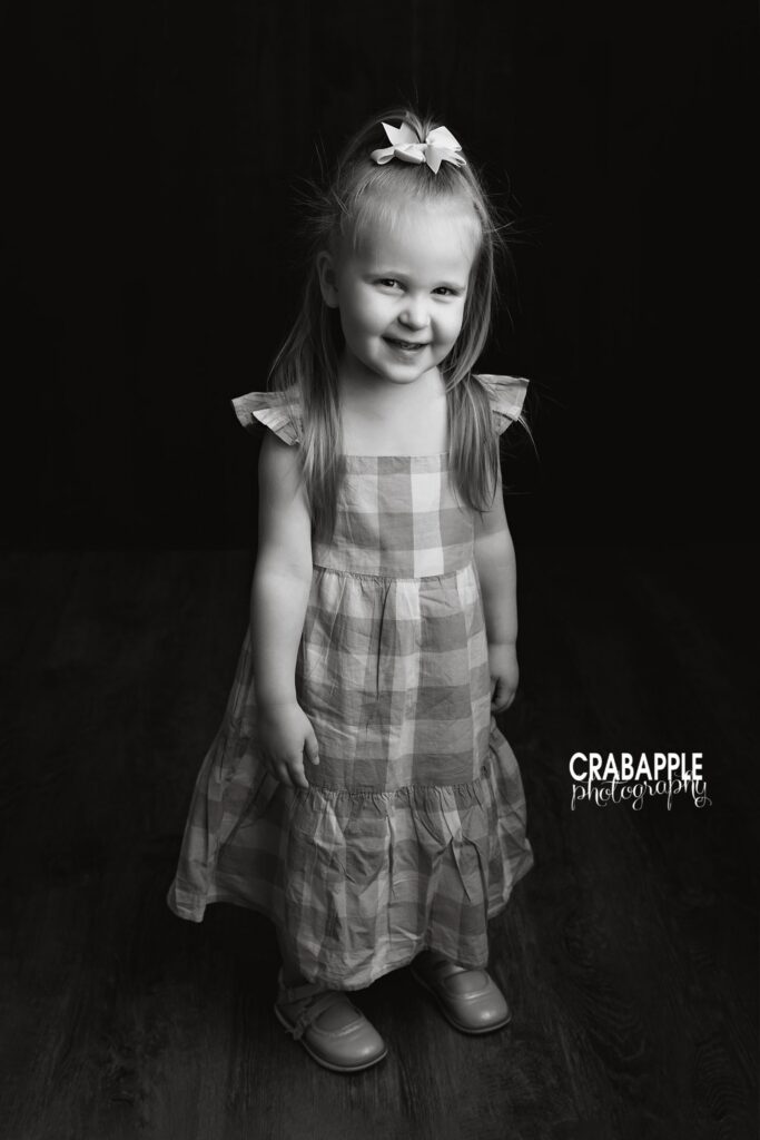 Black and white full body portrait of older sister in studio
