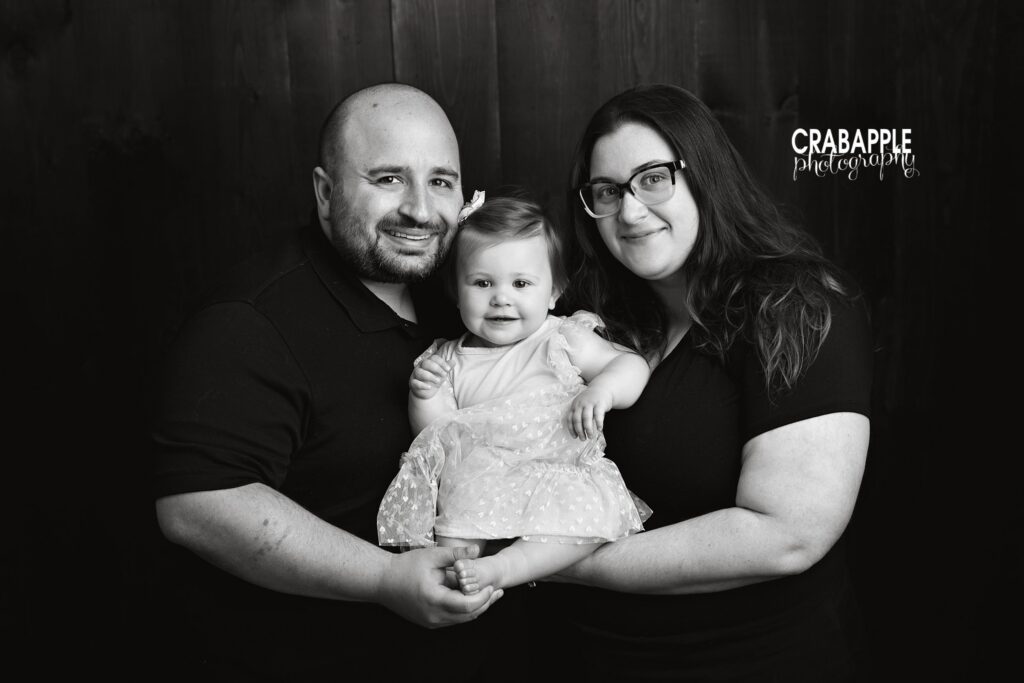 Black and white indoor family portrait with parents and one year old baby for custom wall art inspiration
