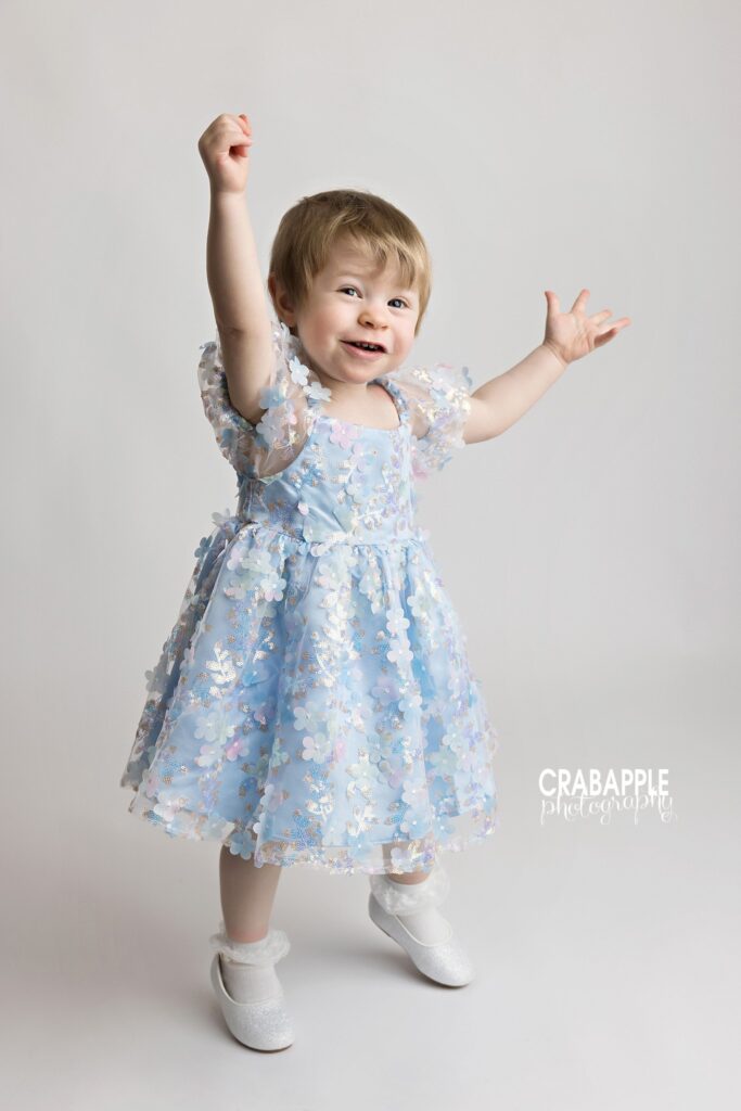 Toddler girl dancing in studio with white background
