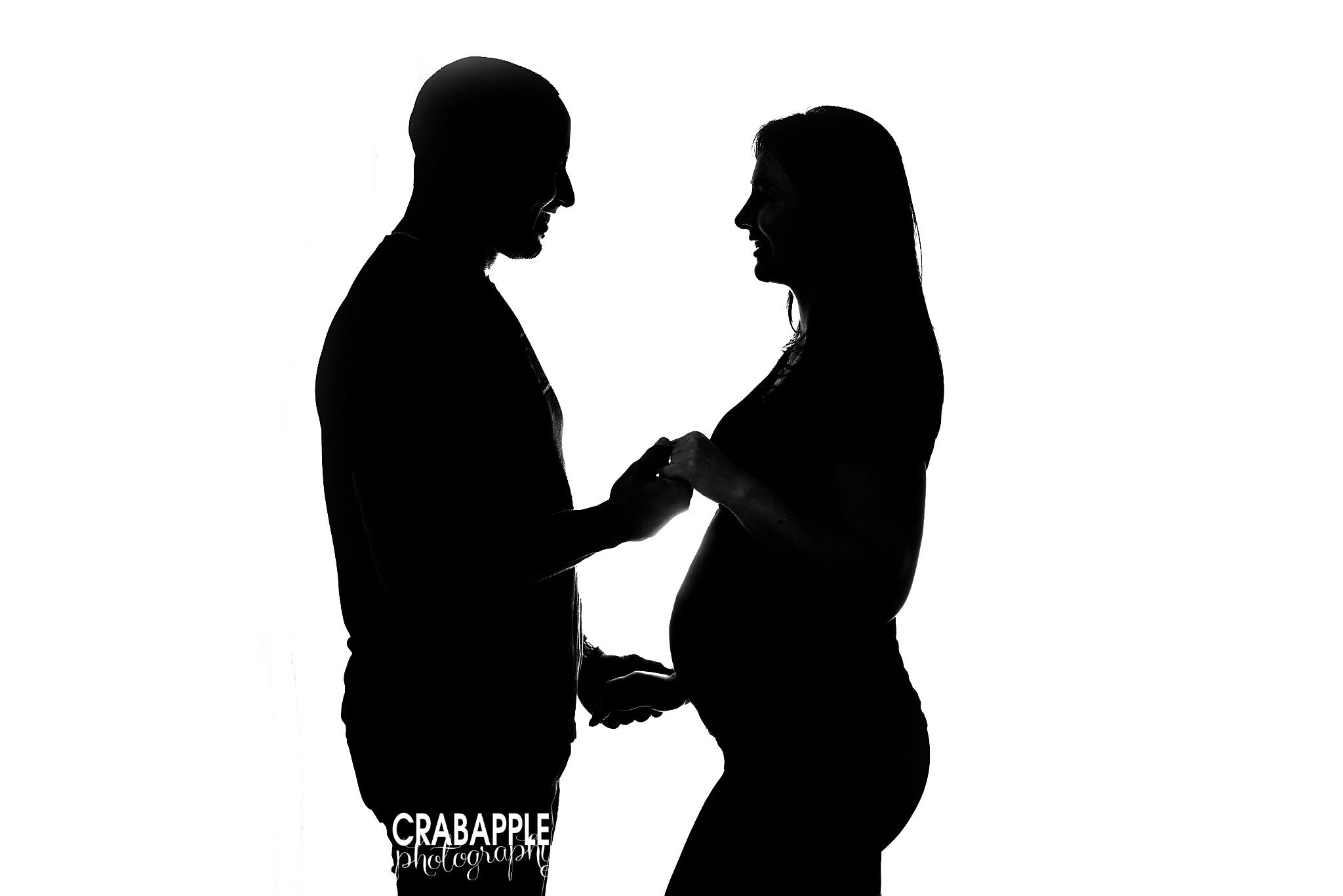 Silhouette maternity photo of couple embracing during studio maternity session

