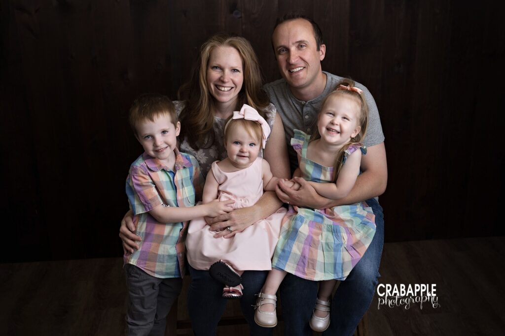 Family of five smiling together during studio family photo session near Groton MA
