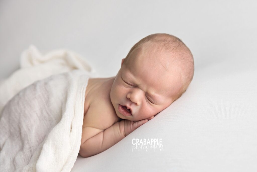 sleeping newborn baby boy during neutral newborn photography session
