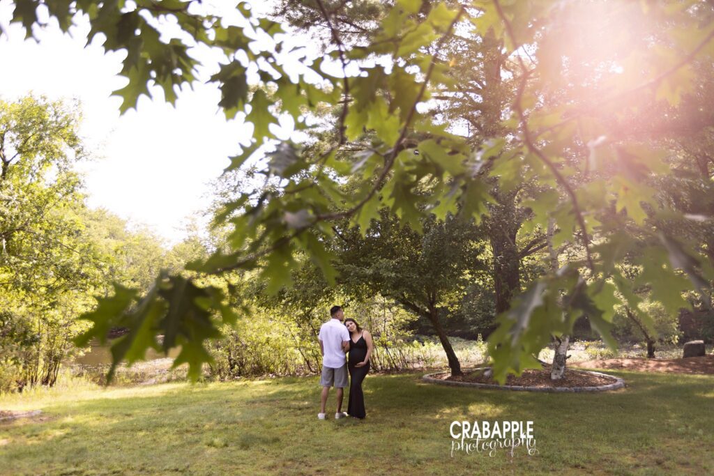 expecting couple embracing during outdoor maternity photos at sunset
