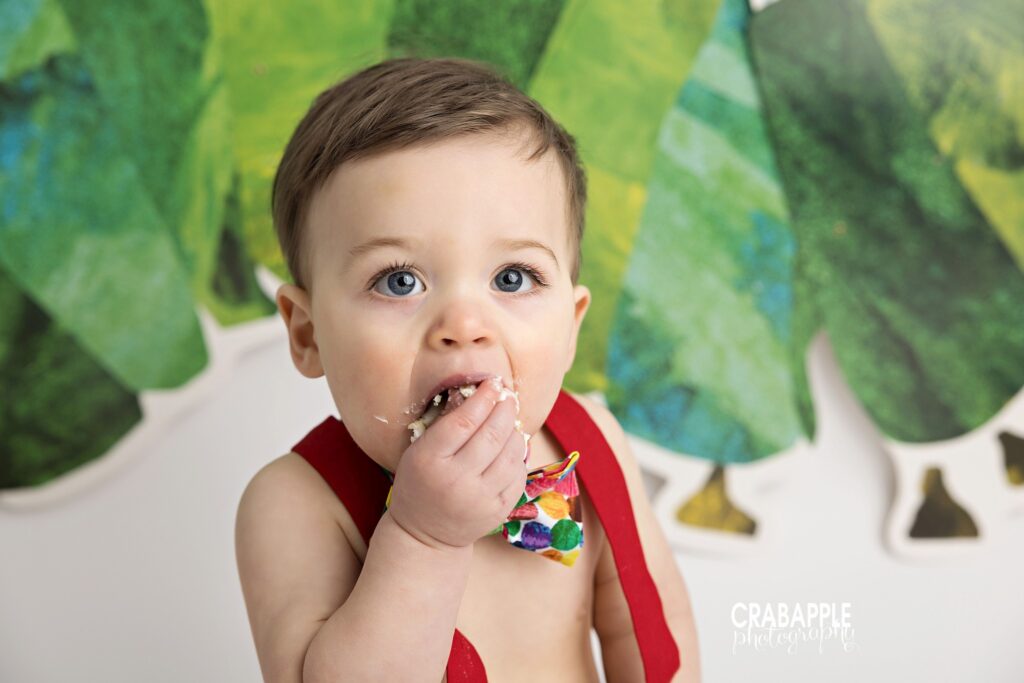 Close up of one year old boy eating cake during themed birthday session
