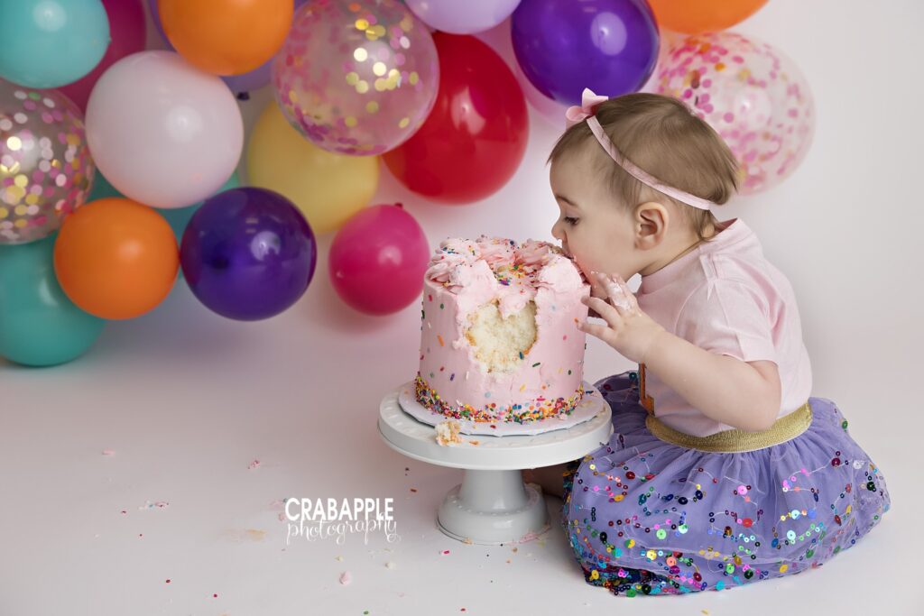 Frosting Fingers One year old eating birthday cake with frosting-covered fingers
