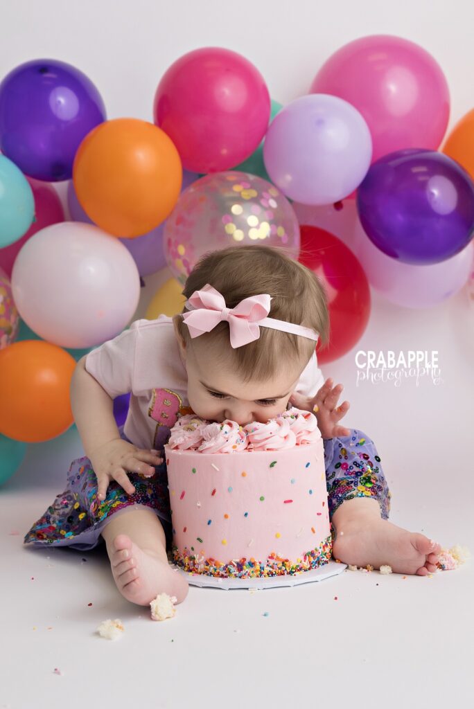 First Bite One year old girl leaning face first into birthday cake