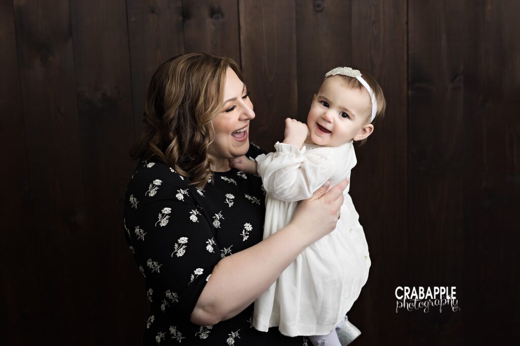 Mother and Daughter Mother holding her one year old daughter during studio portrait session