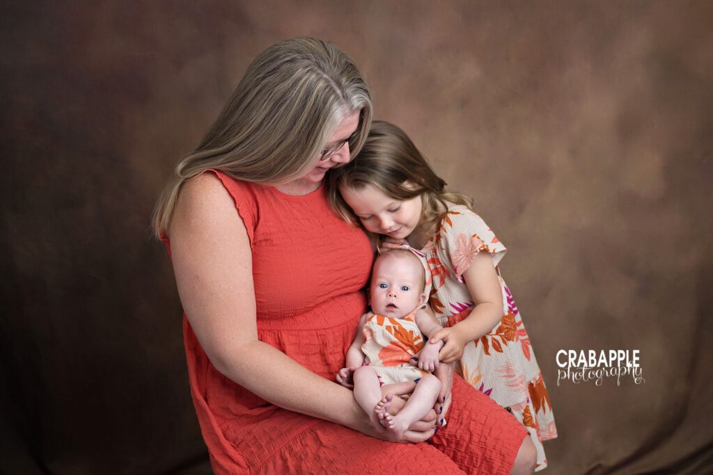 Family portrait with mom and daughters during baby milestone photography session
