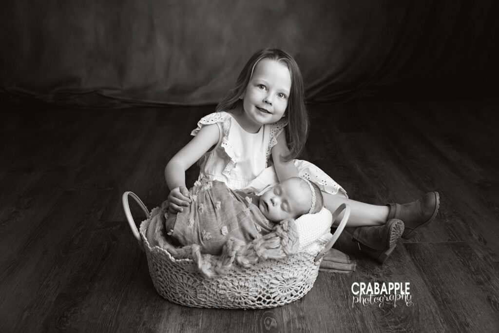 Black and white sibling portrait featuring baby girl and her older sister
