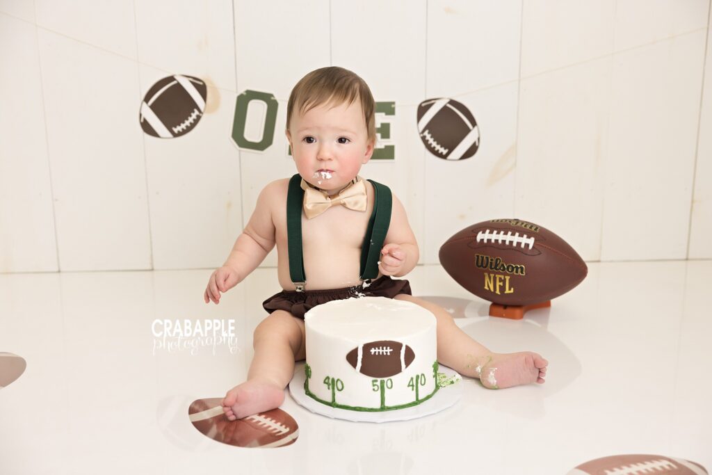 One year old birthday photography with football themed cake smash setup photographed in Andover studio
