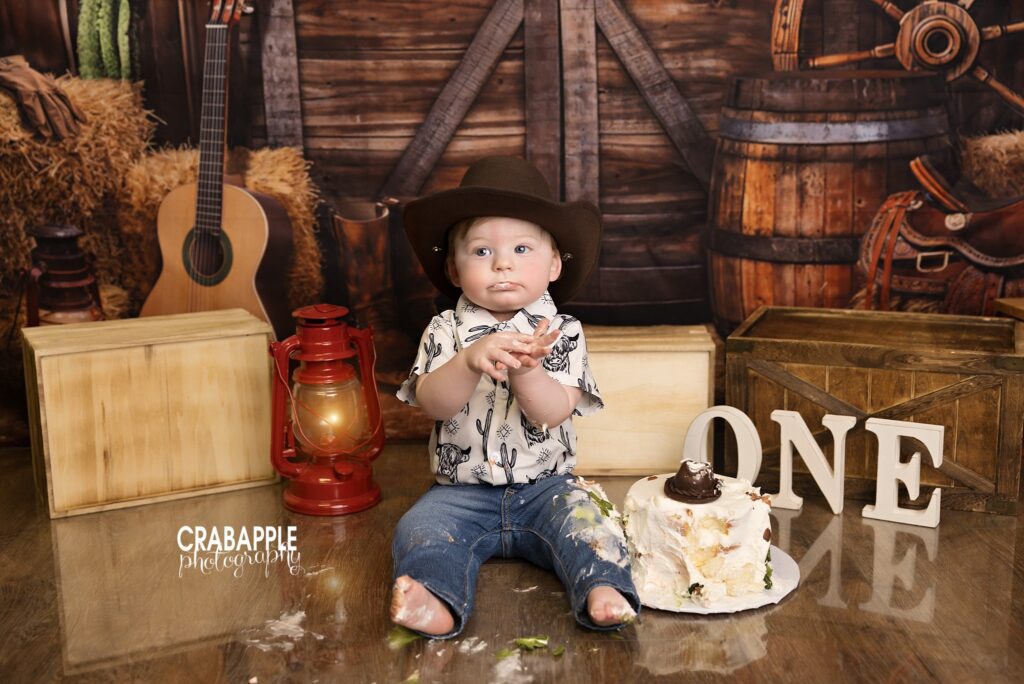 Cowboy inspired first birthday photography with rodeo themed cake smash decorations and rustic styling