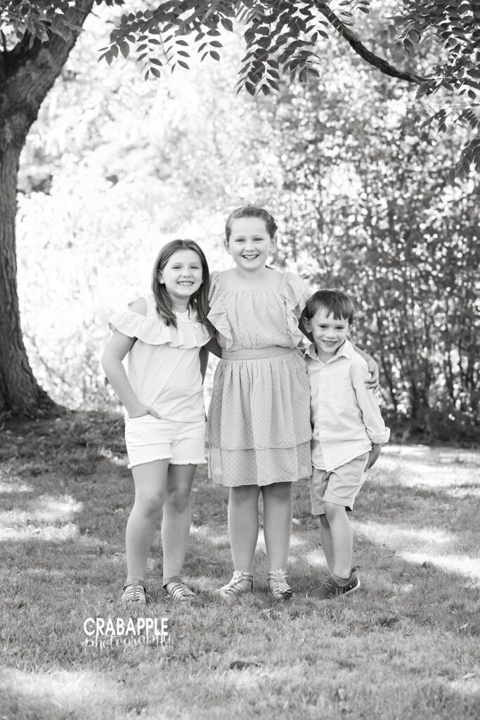 Black and white portrait of three siblings during outdoor family photos
