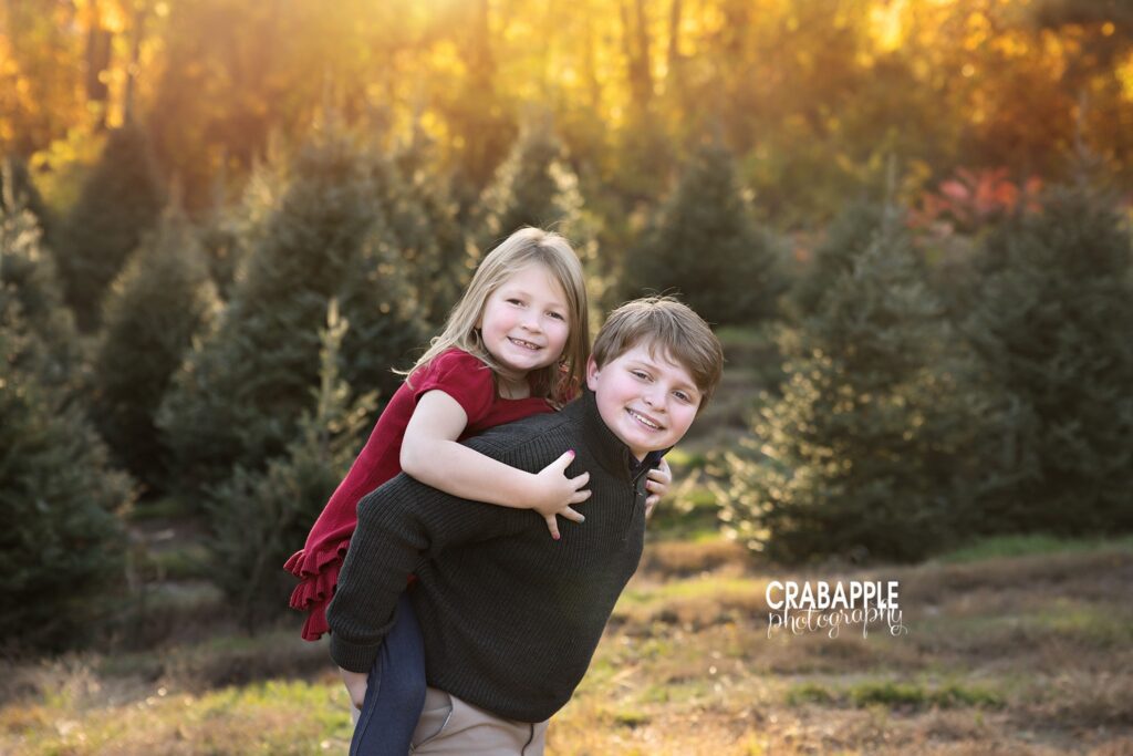 Brother giving sister piggy back ride Older brother giving his younger sister a piggyback ride among the trees during family photos