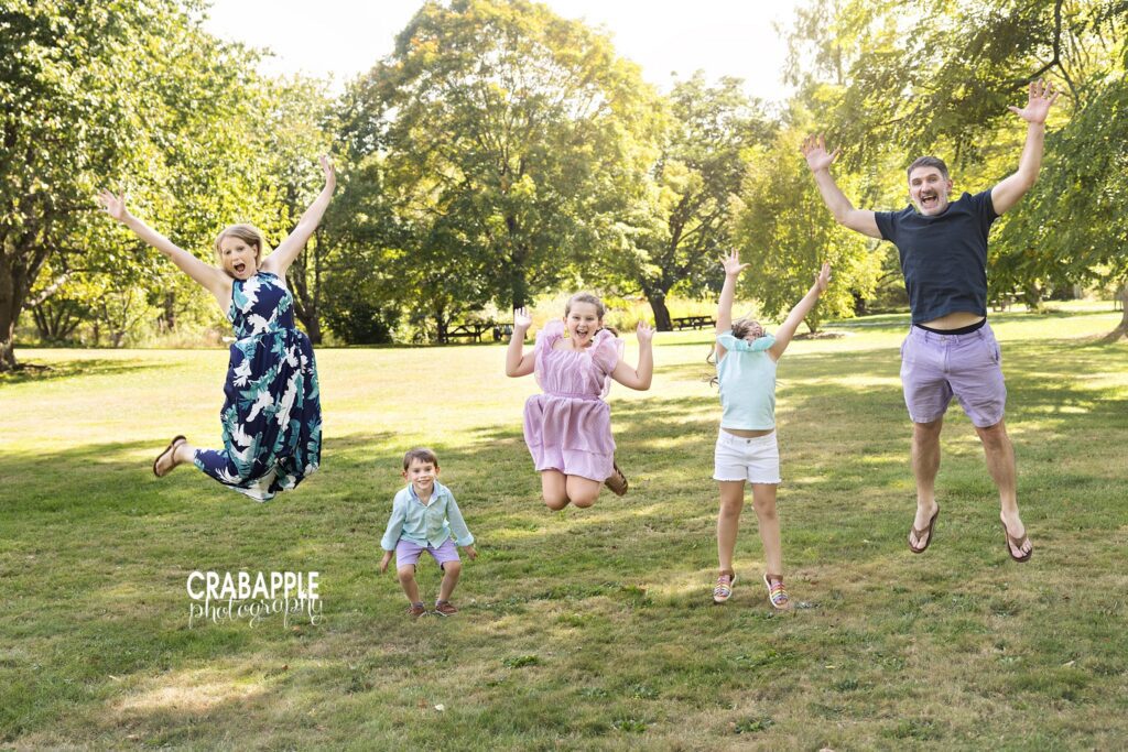 Family of five jumping together during outdoor fall family portraits
