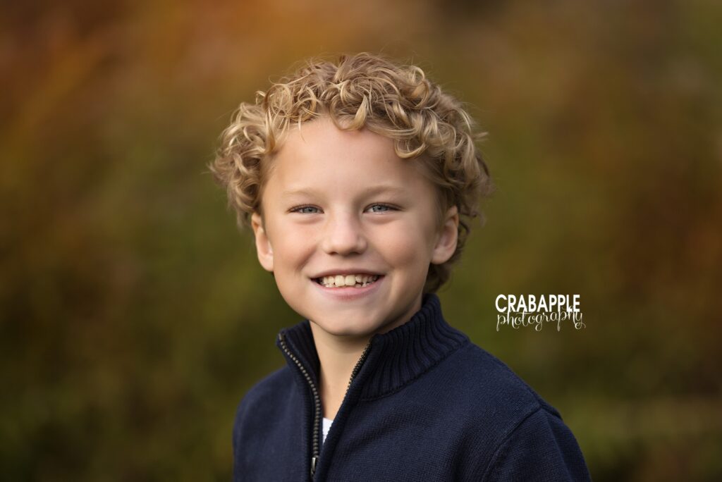 North Reading MA fall child portrait Young child smiling during a fall portrait session at Ipswich River Park in North Reading MA
