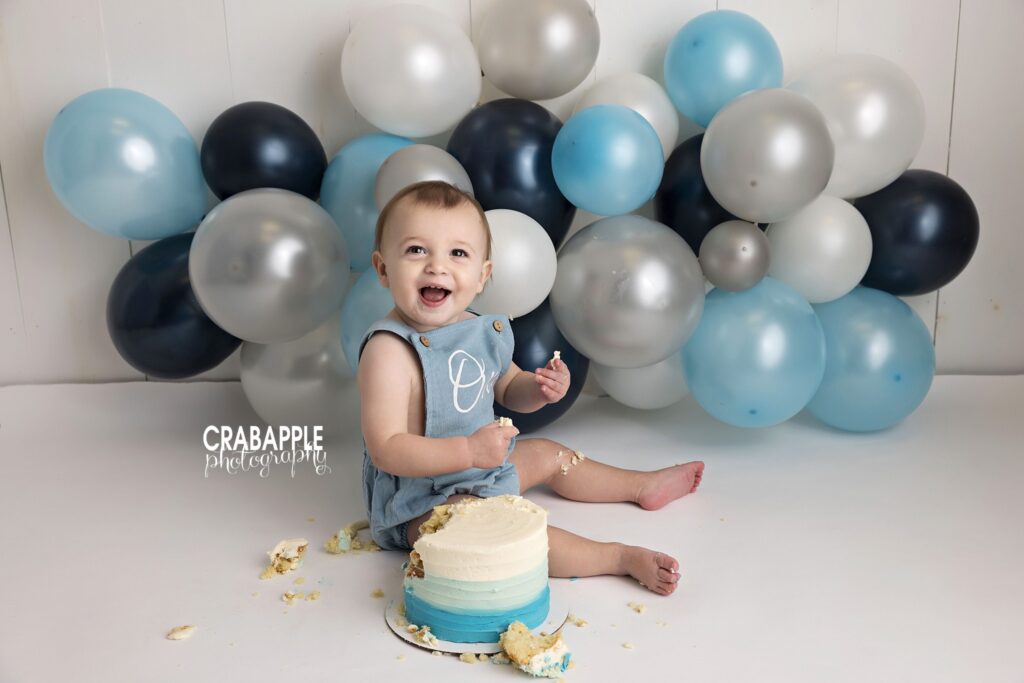Baby boy first birthday cake smash portrait Baby boy celebrating his first birthday during a studio cake smash