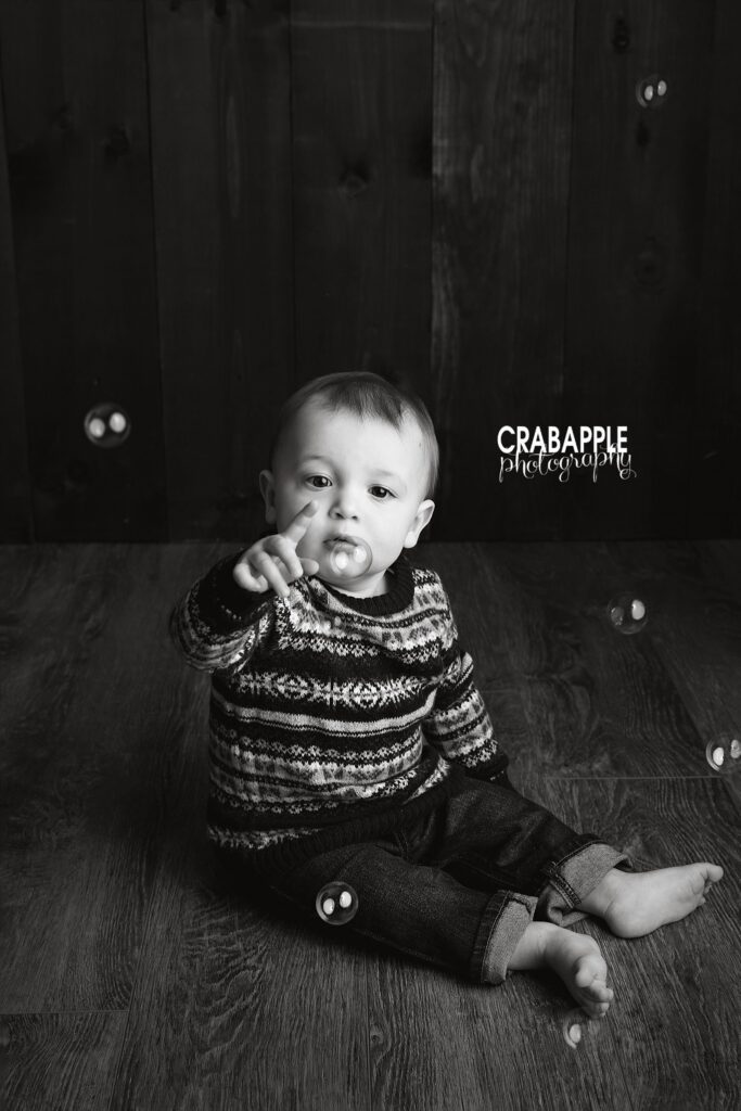 Black and white 1-year portrait with bubbles Black and white portrait of a baby boy in a striped sweater with bubbles