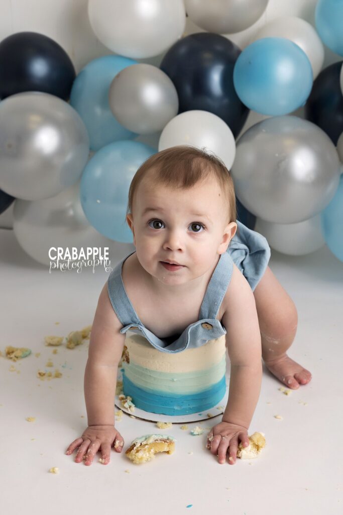 Baby crawling through his cake smash Baby boy crawling through his cake during a first birthday photography session