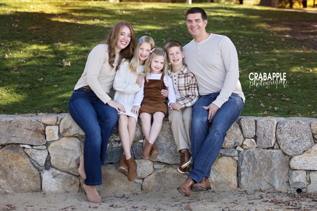 Family of five sitting together outdoors during a fall portrait session
