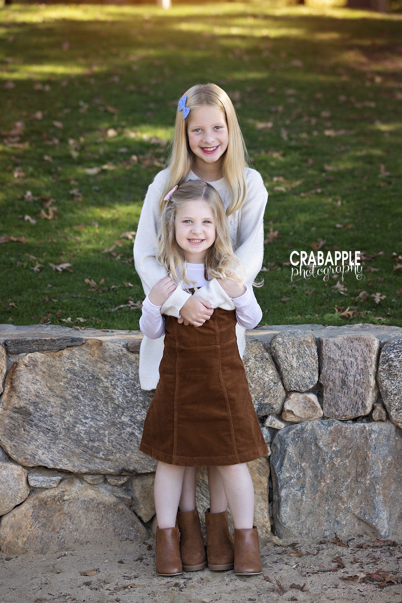 Two sisters posing together during their family's fall photo session
