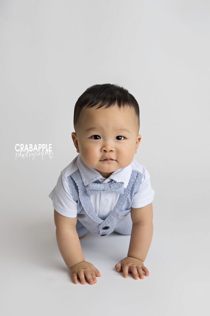 10-month-old baby boy crawling towards camera during a studio milestone session