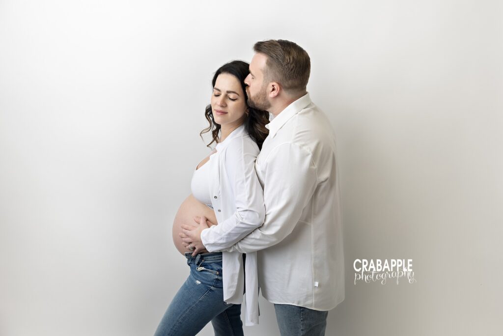 Casual maternity couple portrait Expecting couple wearing jeans and white shirts together during an in-studio maternity session