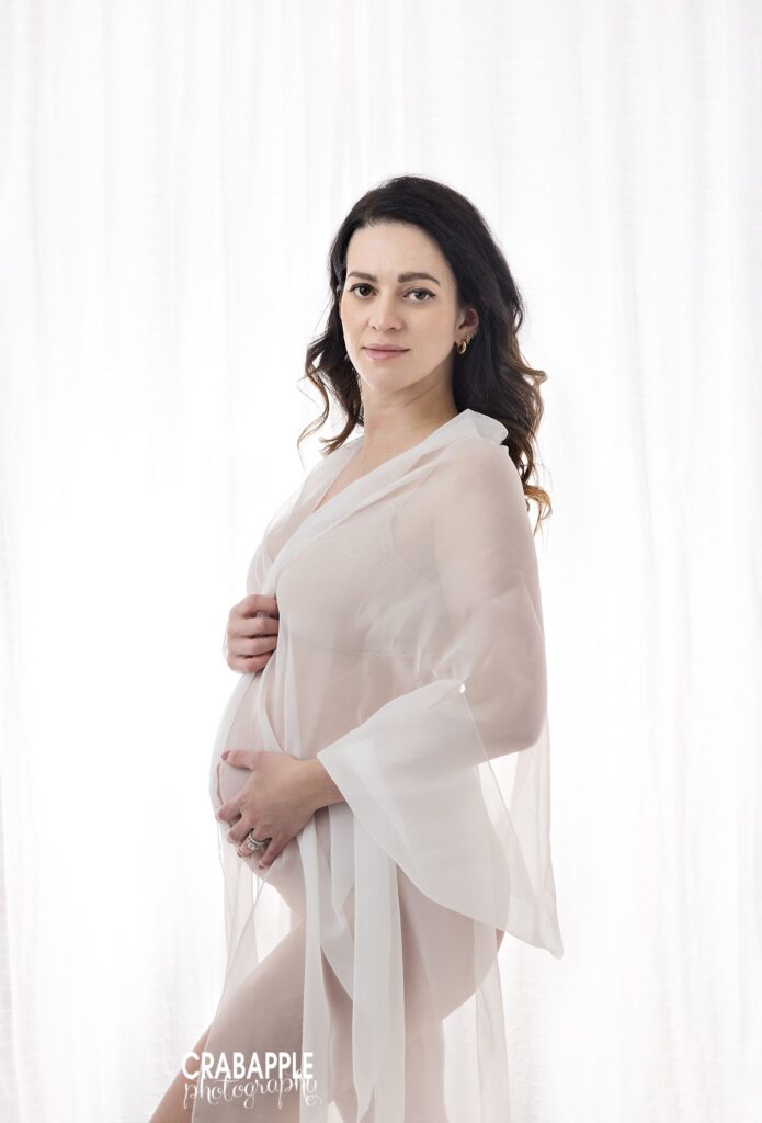 White robe maternity session Expecting mother photographed in a sheer white robe during an in-studio maternity session