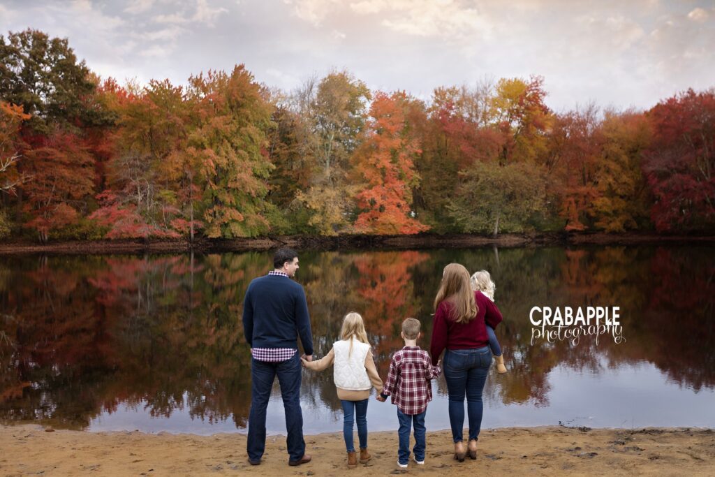 Family looks out at a lake and fall foliage during fall photos