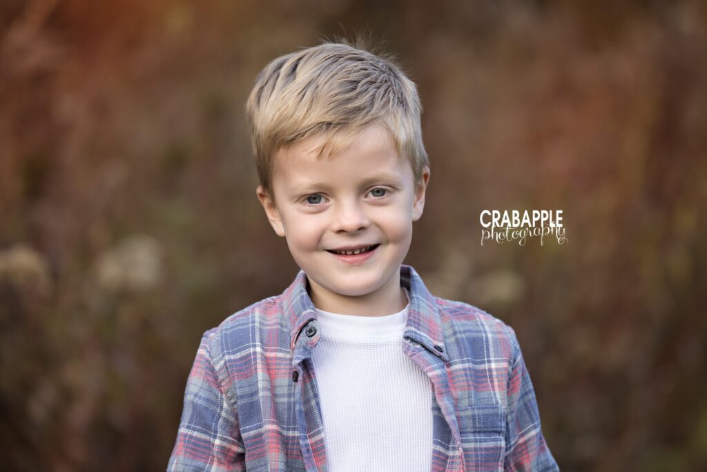 Young boy wears plaid shirt during fall family photos