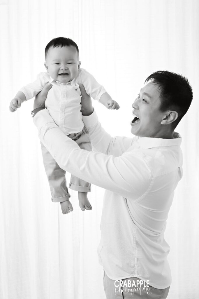 10 month old baby boy being lifted by his dad during a studio photography session