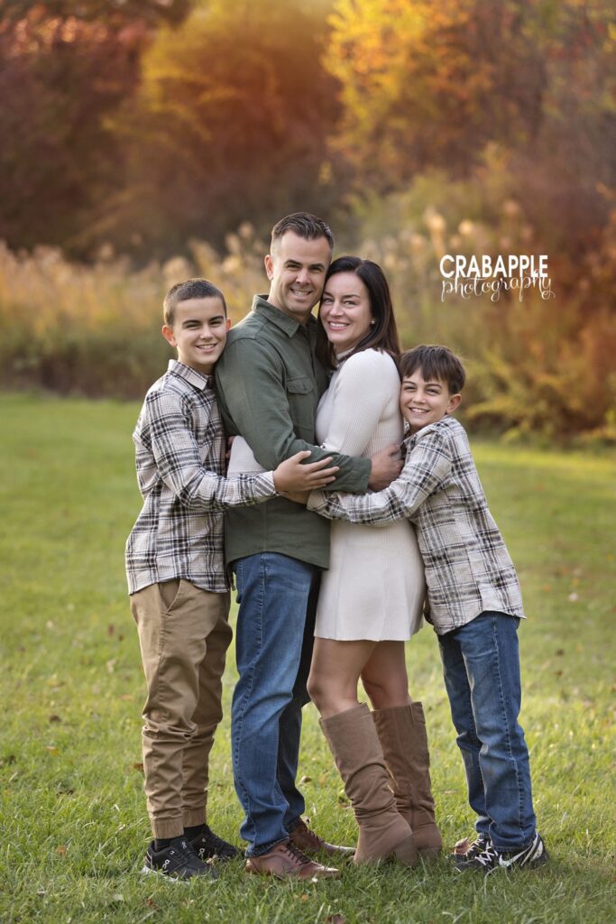 Parents and two children hugging during a fall portrait session at Ipswich River Park