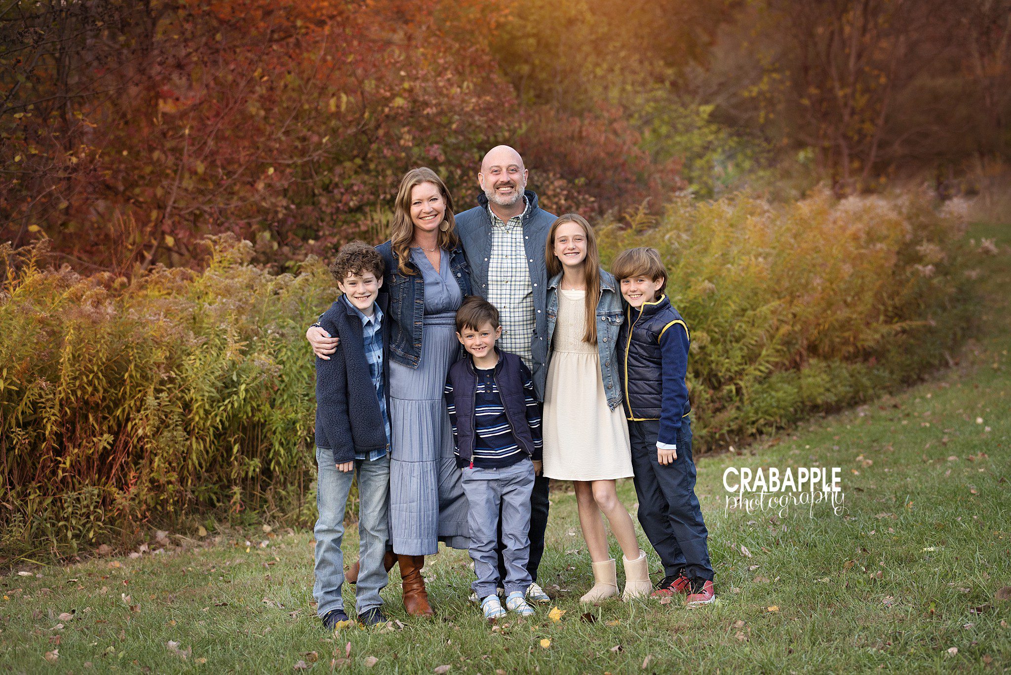 Family of six in coordinating but not matching outfits during fall family portraits