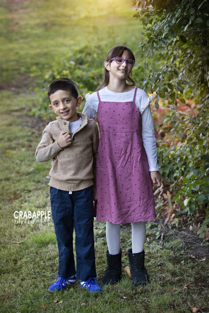 Natural sibling fall portrait Brother and sister standing together during a natural outdoor fall portrait