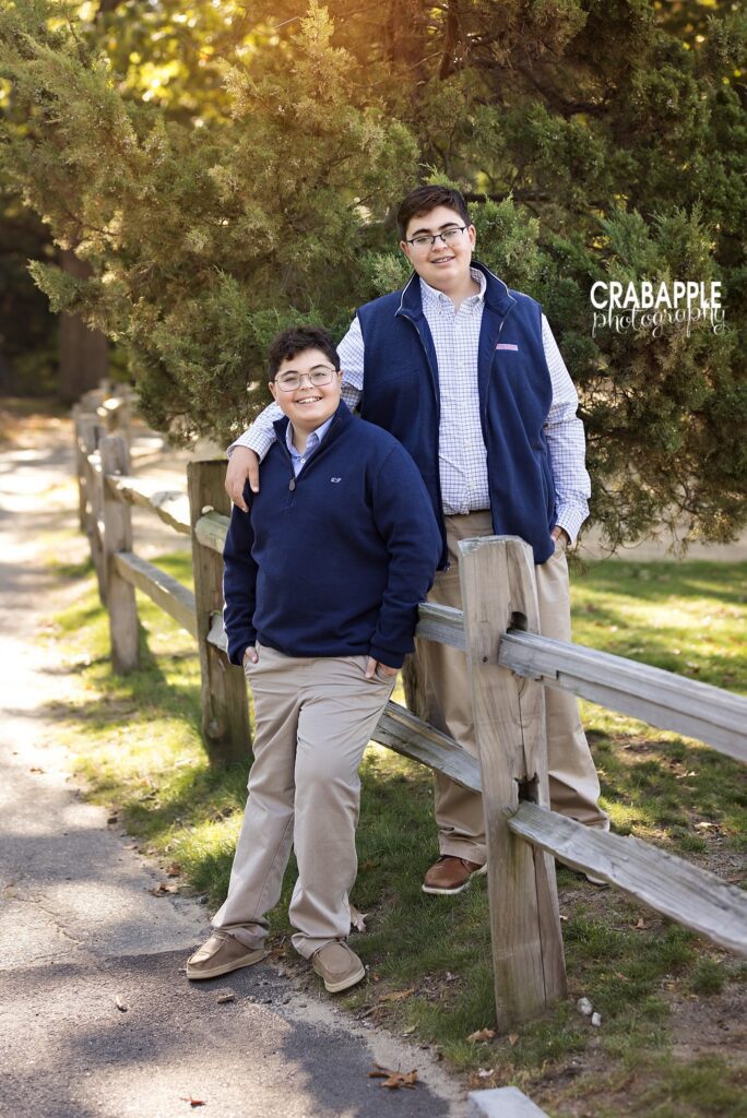Brothers in a Medford fall portrait Two brothers posing together along a wooded park path during fall photos in Medford
