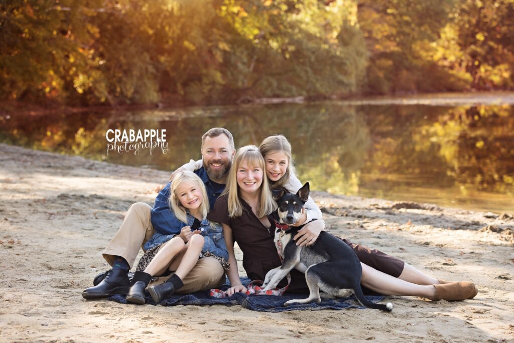 Family sitting together on the ground during an outdoor fall photo session in Medford