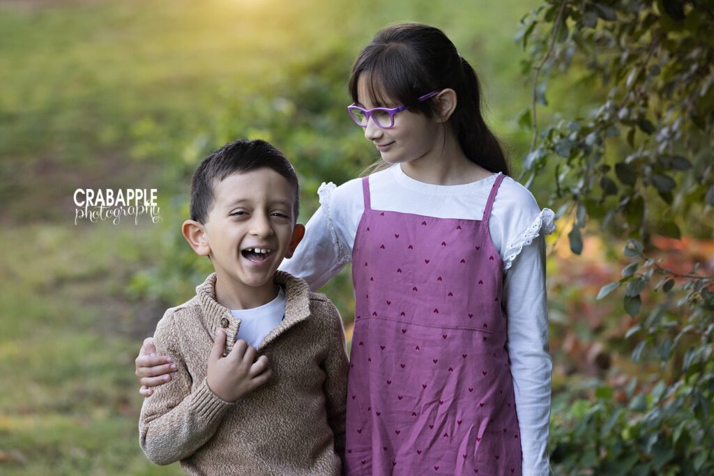 Siblings laughing together Brother and sister laughing together during an outdoor fall photo session
