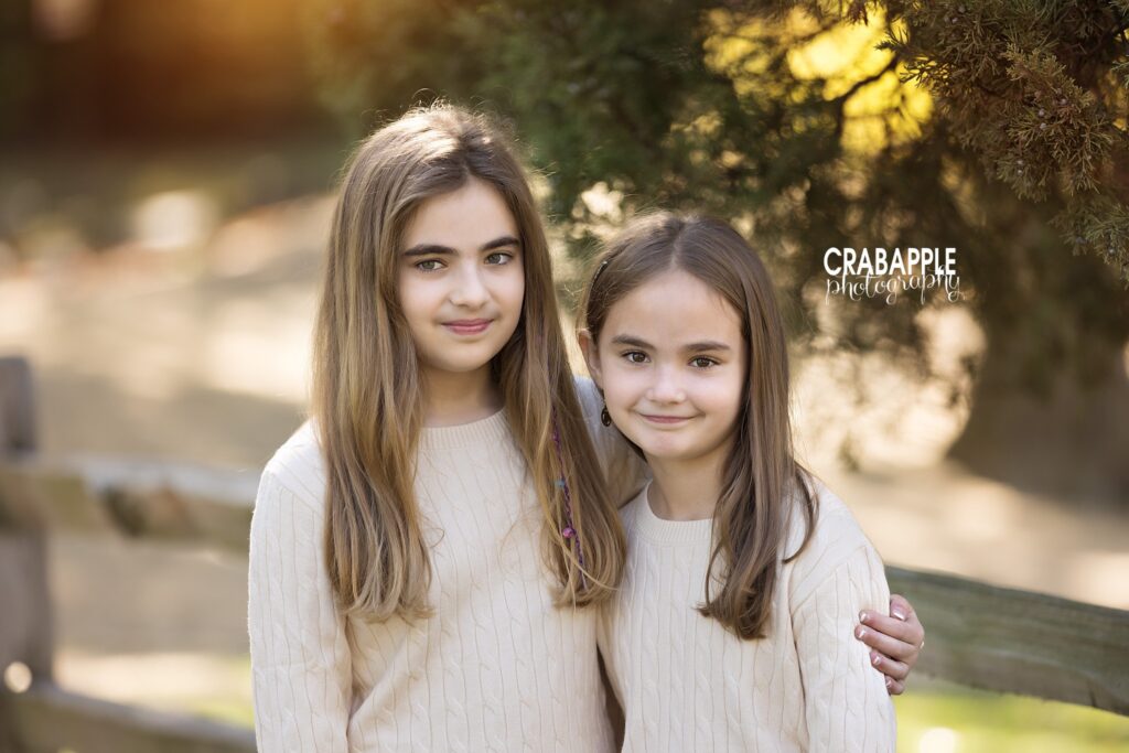 Sisters during fall photos Two sisters standing close together for a natural fall portrait in Medford