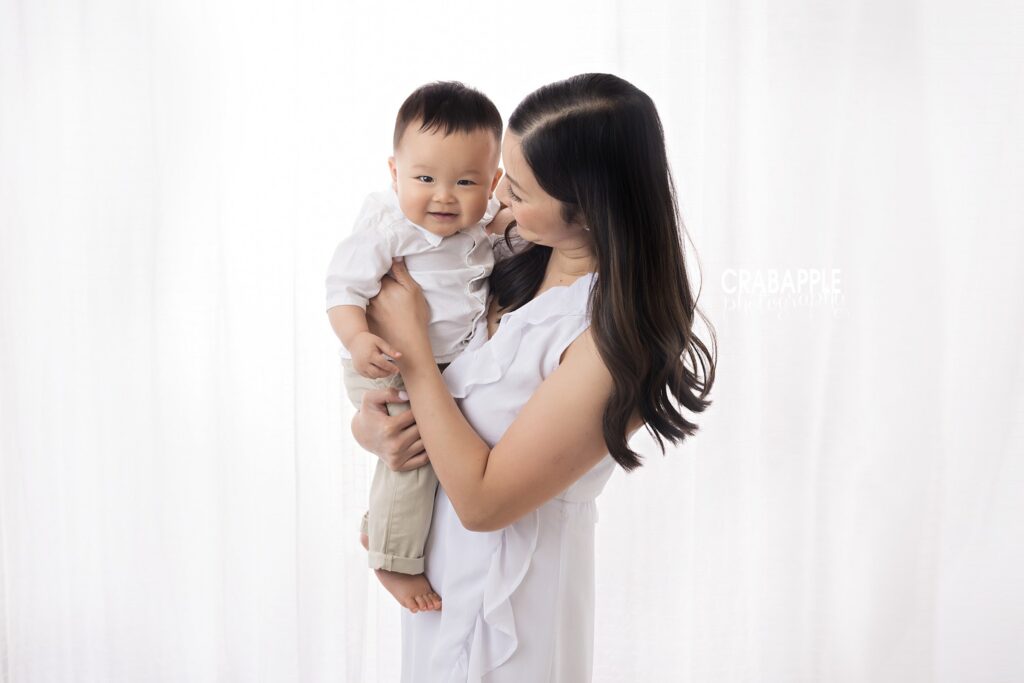 10-month-old baby boy being held by his mother during a studio photography session