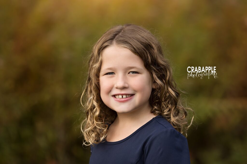 Close portrait of a smiling girl surrounded by soft autumn colors in North Reading