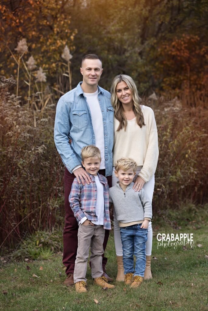 Family of four standing together among the fall foliage at Ipswich River Park in North Reading