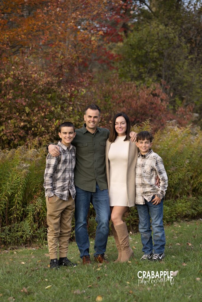 Family standing together in front of fall foliage in North Reading