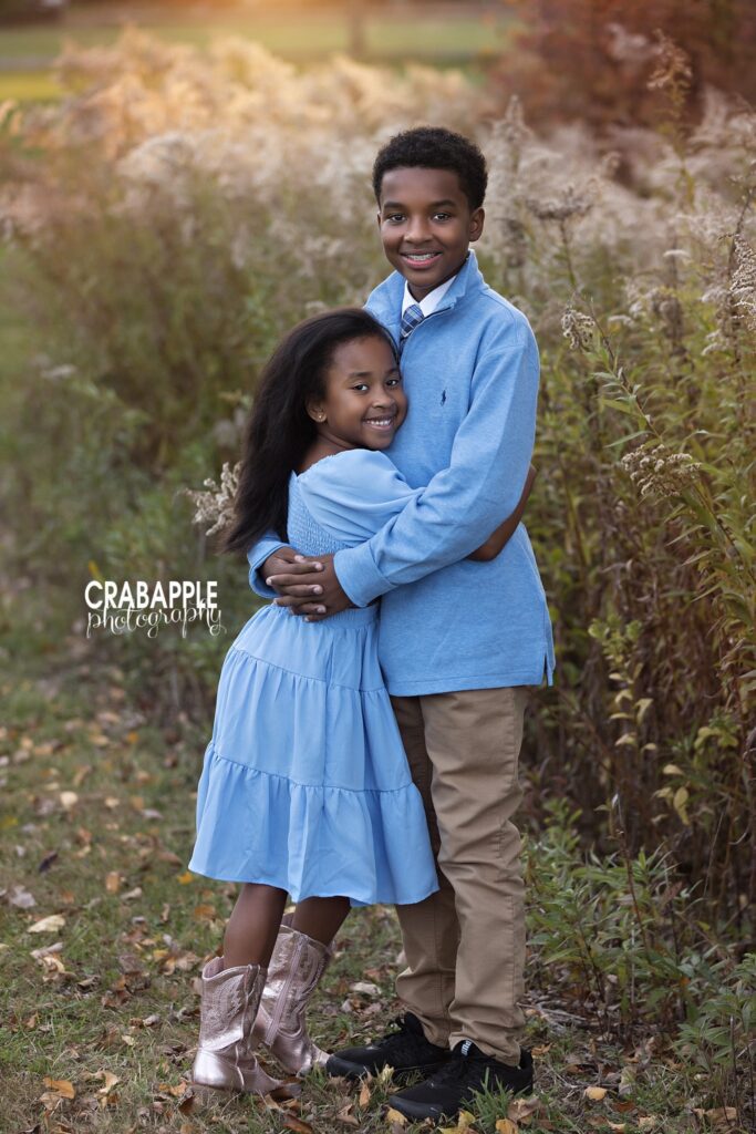 Powder blue brother sister fall photo Brother and sister wearing powder blue hug during fall family photos