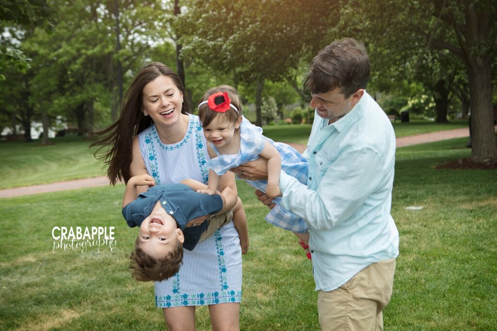 Mom and dad play with kids at a park for outdoor cake smash and family photos