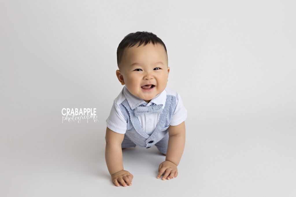 10-month-old baby boy crawling on the studio floor during milestone session