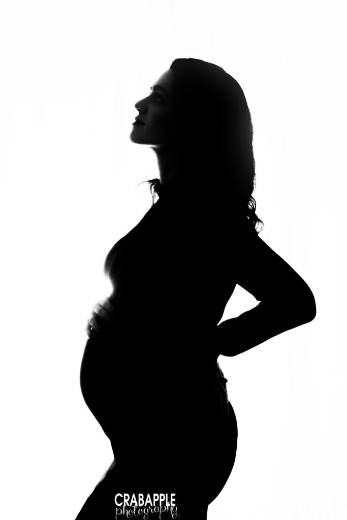 Backlit maternity silhouette Artistic silhouette maternity portrait of an expecting mother created with dramatic studio lighting