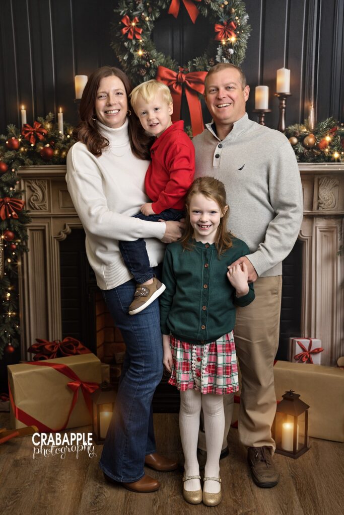 Family standing together for a Christmas portrait in a warmly lit holiday studio set	
