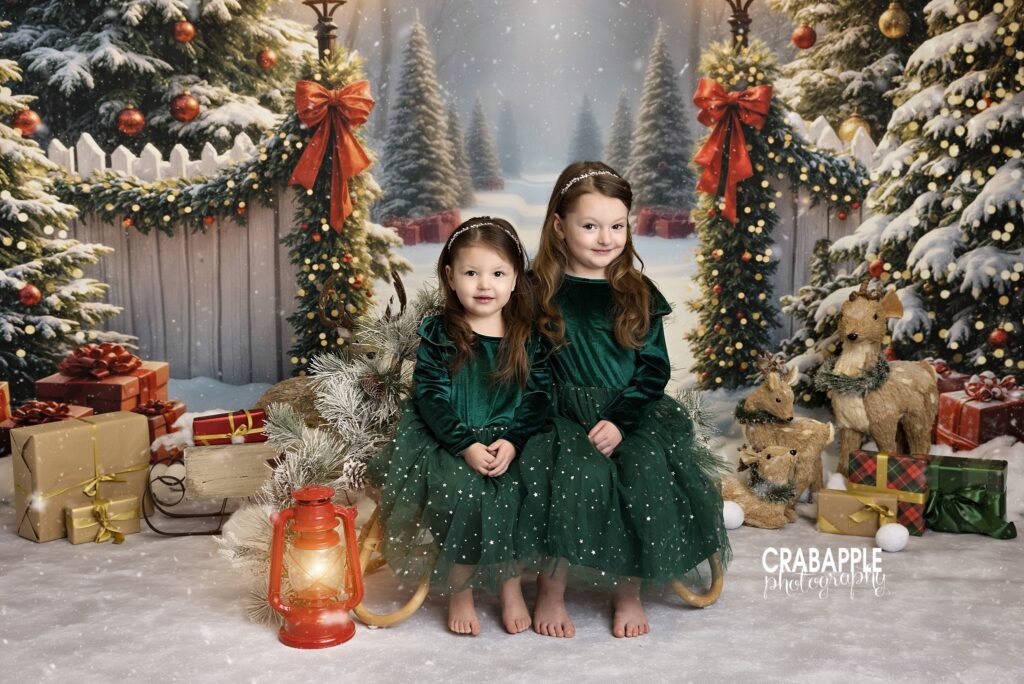 sisters smiling together in a Christmas portrait at the holiday studio	