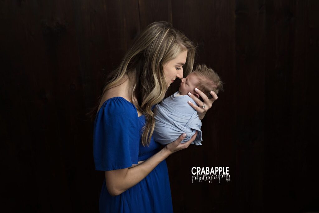 Mother and newborn baby boy sharing a sweet nose-to-nose portrait
